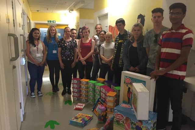 The students handing over the toys to the nurses at the Kipling Ward SUS-160819-155351001