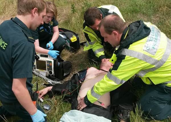 Leigh Sayers being treated by paramedics after coming off his bike on Jury's Gap Road SUS-160109-095950001