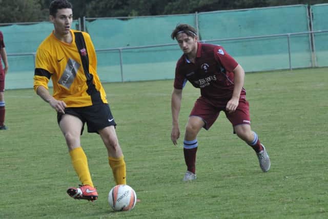 Jake Sherwood keeps a close eye on a Seaford Town opponent