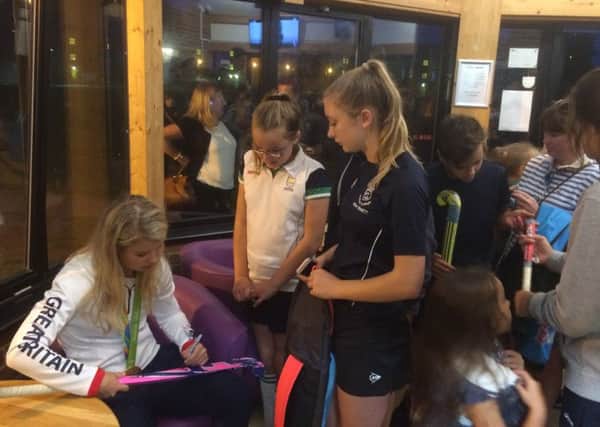 Sophie Bray signs a hockey stick for Chichester youngsters
