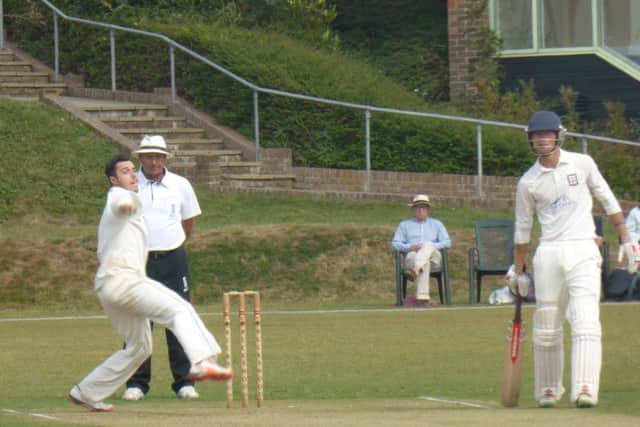 Jed O'Brien bowling for Priory as Shawn Johnson looks on from the non-striker's end.