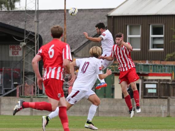 Sam Cole goes up for a header during Hastings United's weekend win over Camberley Town. Picture courtesy Scott White