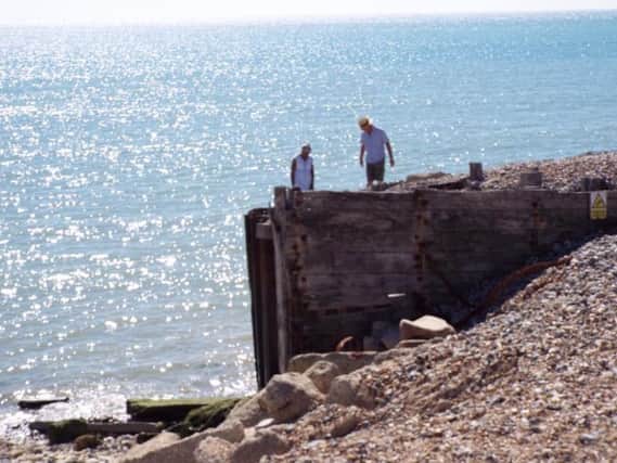 Couple climbing sea defences at Cuckmere Haven. Photo by Patrick Coffey.