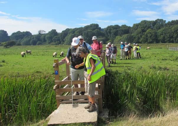 London Blind Walkers group, enjoying the local countryside, are assisted over a stile. SUS-160914-115714001
