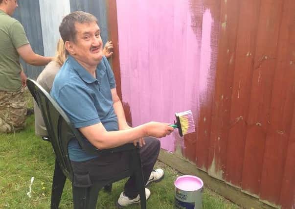 Peter Williams painting the fence