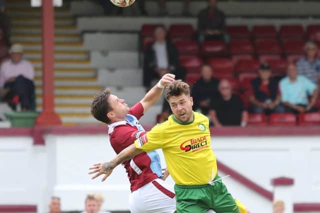 Hastings United forward Frannie Collin contests an aerial ball against Godalming. Picture courtesy Scott White
