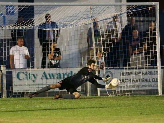 Hastings United goalkeeper Ryan Nicholls makes one of his three saves during the penalty shoot-out. Picture courtesy Scott White