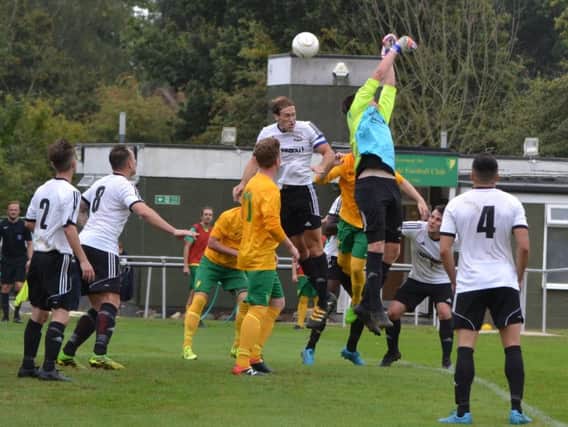 Bexhill United skipper Billy Trickett heads clear from a Holmesdale corner. Picture courtesy Alan Coomes