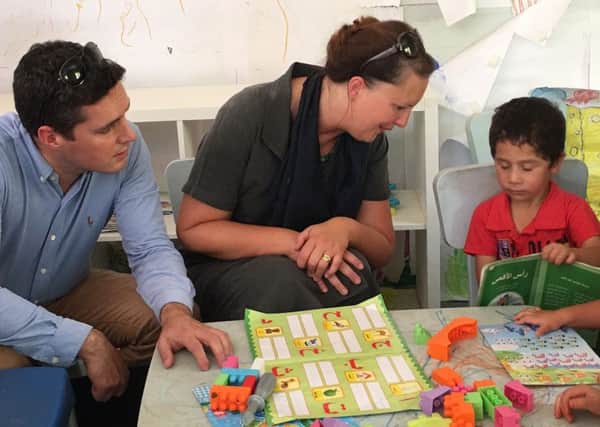 Bexhill and Battle MP Huw Merriman and Banbury MP Victoria Prentis with a child refugee in Jordan SUS-160921-151826001