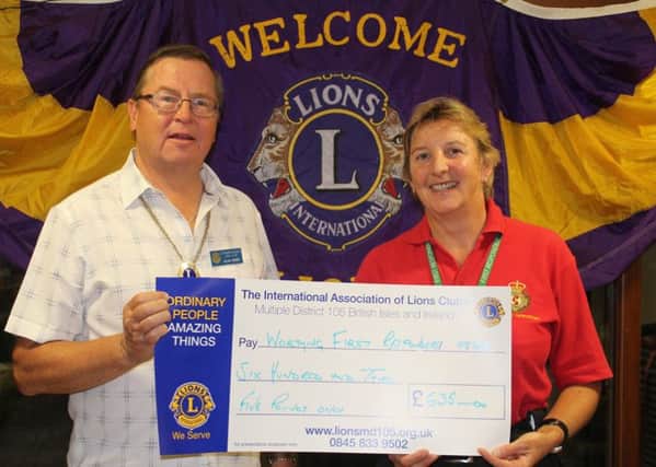 Littlehampton District Lions Club president Alan Kerry presents a cheque to Jenny Lindsey from Worthing First Responders