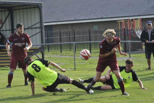 Cam Burgon comes away with the ball as a couple of Wick players go to ground. Picture by Simon Newstead