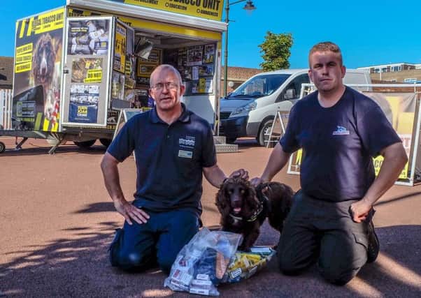 Roger Cohen with Stu Phillips, from BWY Canine Ltd, provider of the sniffer dogs, and Yoyo with tobacco seized from a shop in Bexhill