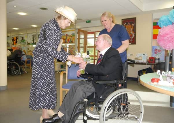 HRH is presented with a posy by QAHH resident, Ted Bullen
