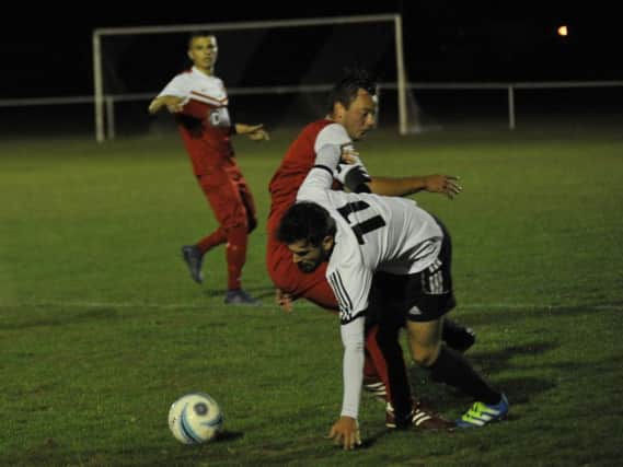 Bexhill United wide midfielder Matt Cunnington tries to turn away from a Seaford Town opponent. Picture by Simon Newstead