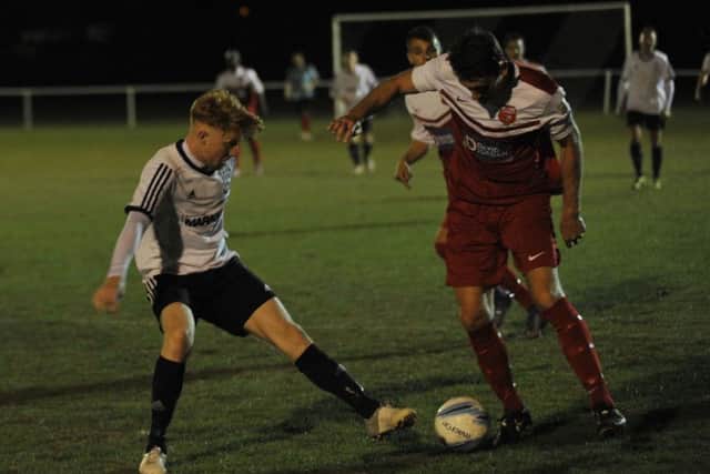 Bexhill United midfielder Wayne Giles goes in for a tackle. Picture by Simon Newstead