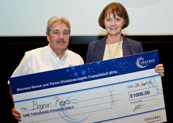 Lynette Gill receives the cheque for Â£1,000 from Ronnie Brown, managing director of Blachere Illumination UK