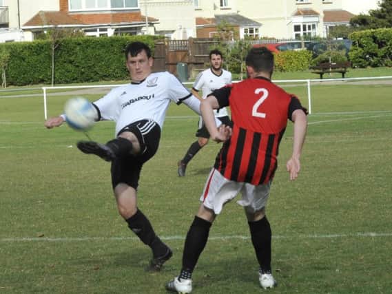 Bexhill United goalscorer Craig Ottley clears the ball away from an AFC Varndeanians opponent. Picture by Simon Newstead