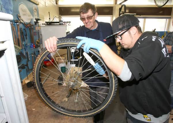 Colin Attle, left, and Tommy Hay working on a bike DM16148438a
