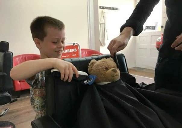 Five-year-old Jack Kelly give his bear a trim at Shoreham Barbers