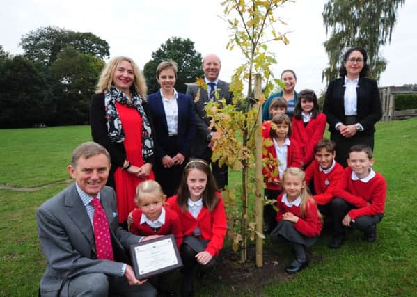 Staff and pupils at Midhurst CofE Primary School, delighted to receive an oak tree from Clive Rowntree, front left, and other members of the firm. Picture: Kate Shemilt ks16000230-1