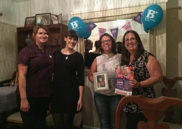 Lisa (right), Michelle (second from right, holding a photo of her mum, Margaret) with therapists Lauren and Bonnie