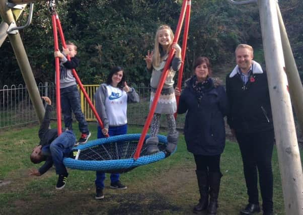 Cllr James Bacon with parents and children enjoying the new swing in Barley Play Space. Photo by James Bacon