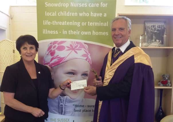 Diana Levantine accepts the cheque on behalf of the Snowdrop Trust from Paul Rose, head of the Masonic Order for Sussex