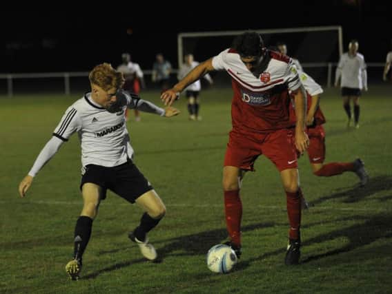 Bexhill United midfielder Wayne Giles closes down a Seaford Town opponent during the recent league meeting between the clubs