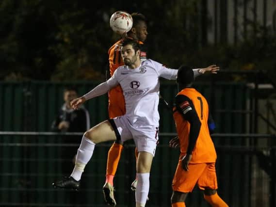 Hastings United defender Richard Davies goes up for a header against Walton Casuals on Wednesday night. Picture courtesy Scott White