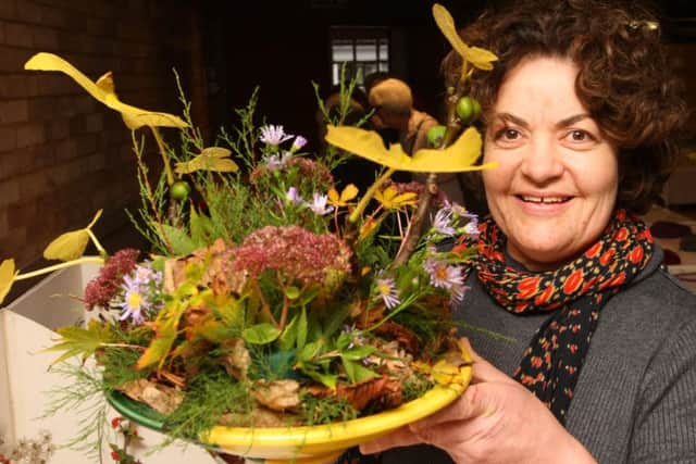 Nikki Dabbs with her floral art exhibit DM16150777a