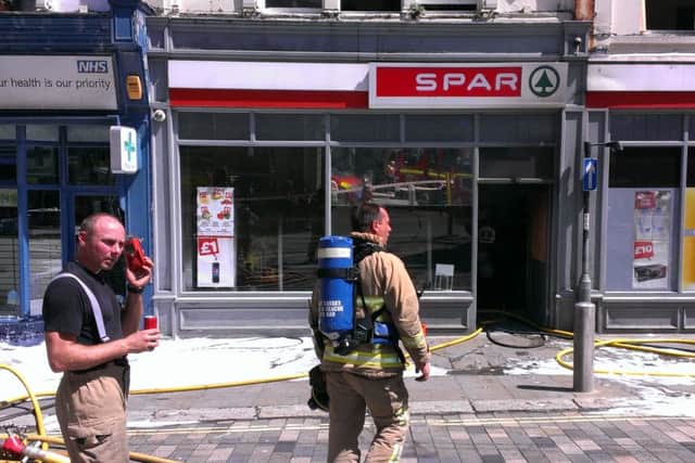 Firefighters outside Spar after the fire on July 19