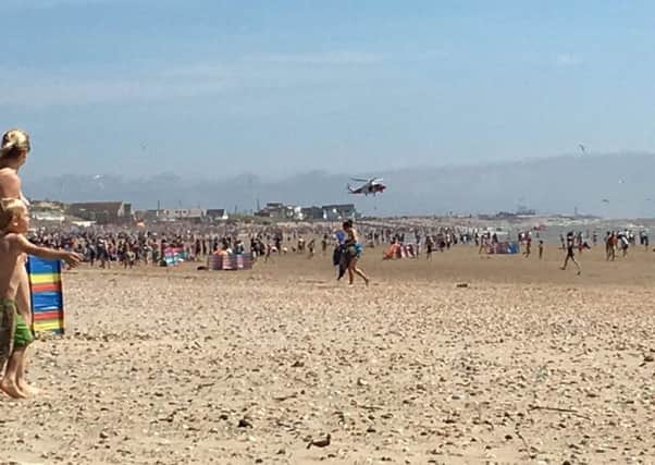 The air ambulance hovering over Camber Sands beach the day two people died after getting into difficulty in the water SUS-160111-153730001