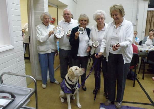 Fittleworth's charity bowlers with a Canine Partners mascot