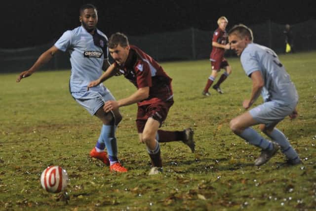 Adam Smith skips between two AFC Uckfield Town opponents.