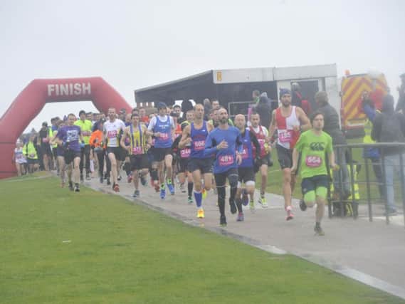 Runners set off in the Poppy Half Marathon from the lawns behind the De La Warr Pavilion. Picture by Simon Newstead
