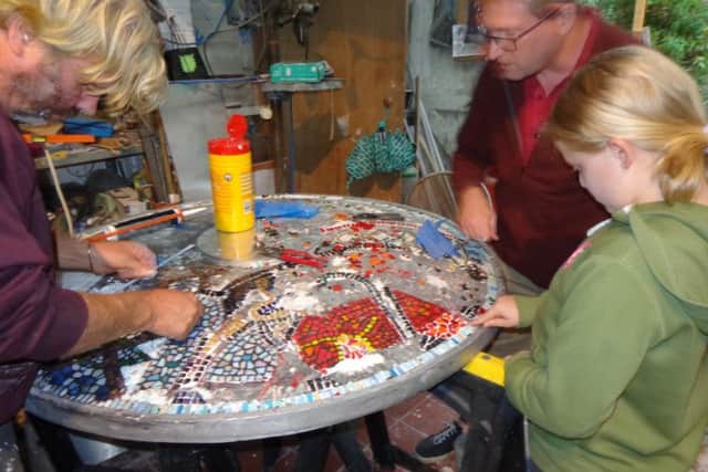 Members of the public were invited to put mosaic tiles on the soldiers' shields