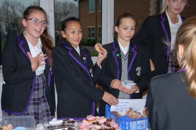 Students do their best to encourage sales on their cake stall