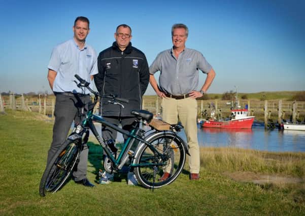 FreeGos Keith Wilson (left) and Richard Davies (right) present the new electric bicycle to Barry Cooper
