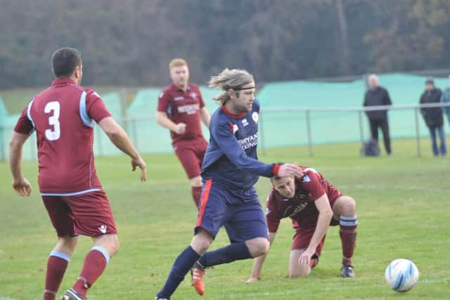 Billingshurst midfielder Paul White tries to skip away from the Common defence. Picture by Simon Newstead
