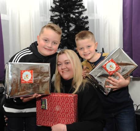 Rachel and her sons Kyle, eight, and Max, six, are handing out Christmas presents for the homeless