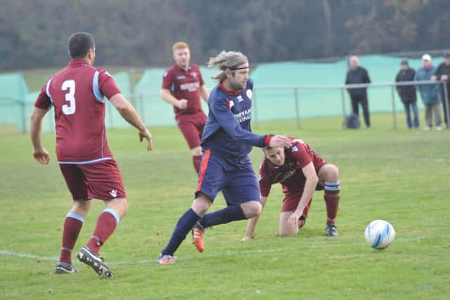 Billingshurst wide player Paul White seeks to skip away from the Common defence.
