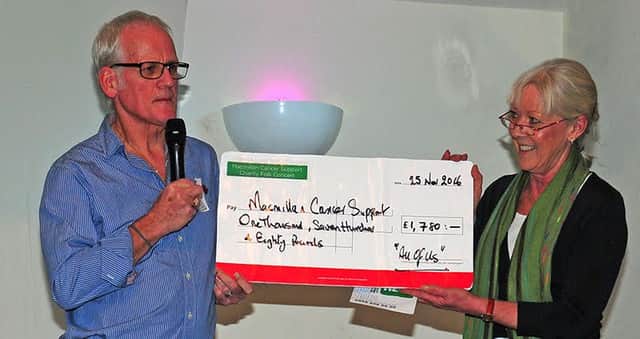 Ronnie Williamson hands the cheque for Macmillan Cancer Support to councillor Sandra Westacott,