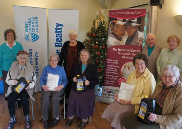 Happy residents at Age UKs Redwood Centre in Haywards Heath showing of their bottles and refill bags of de-icer salt.
