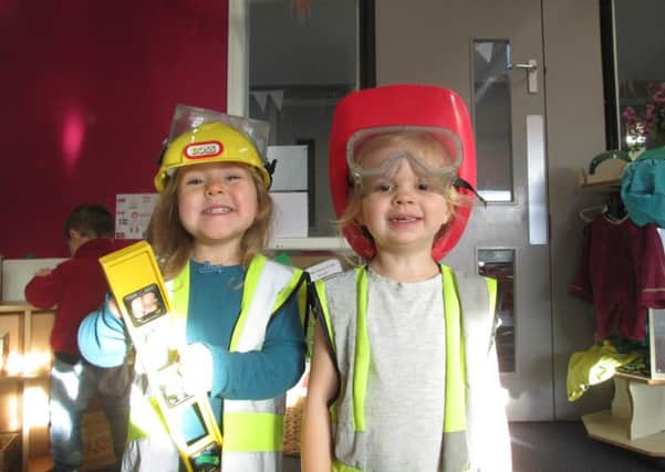 Grace (3) and Isla (3) dressed up and ready to dig, build, manoeuvre and position construction equipment just like they been watching the workmen outside from the garden.