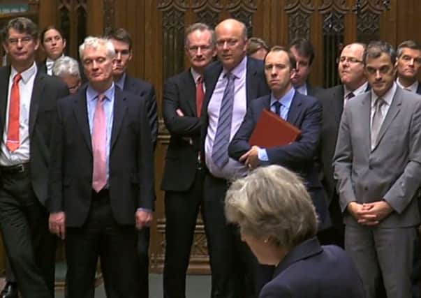 Theresa May speaking in the House of Commons with Transport Secretary Chris Grayling in the background. SUS-161214-131723001