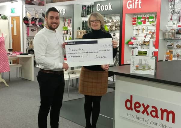 Managing director Bryony Dyer handing the first cheque to Macmillan Cancer Support fundraising manager James Bacharew
