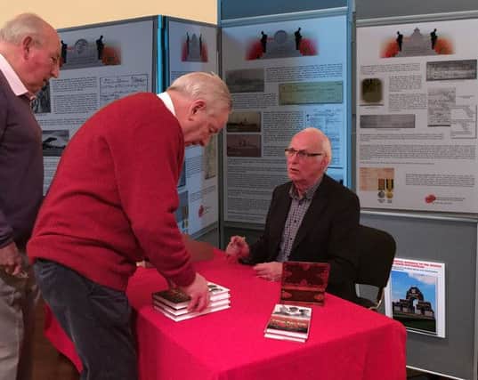 Trevor Purnell signing his book for Peter Rhys Evans, watched by Dennis Clark