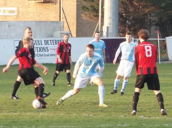 Bexhill United midfielder Gordon Cuddington closes down a Southwick opponent. Picture courtesy Mark Killy