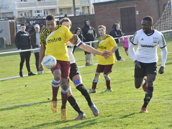 Little Common forward Wes Tate holds off Bexhill United midfielder Billy Trickett. Picture by Simon Newstead