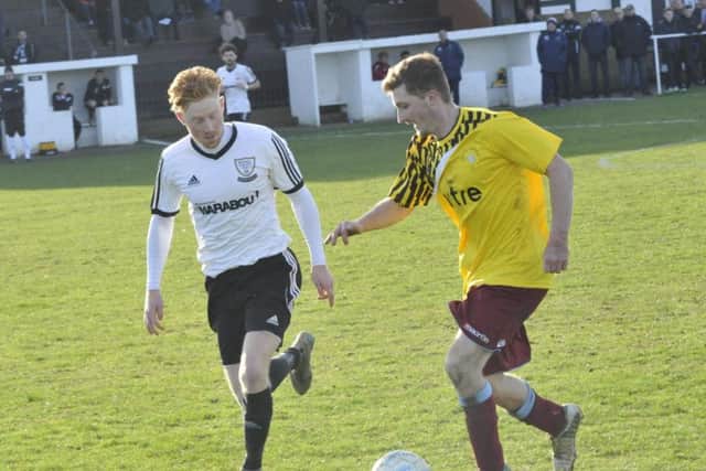 Little Common winger Adam Smith tries to take on Bexhill United midfielder Wayne Giles. Picture by Simon Newstead